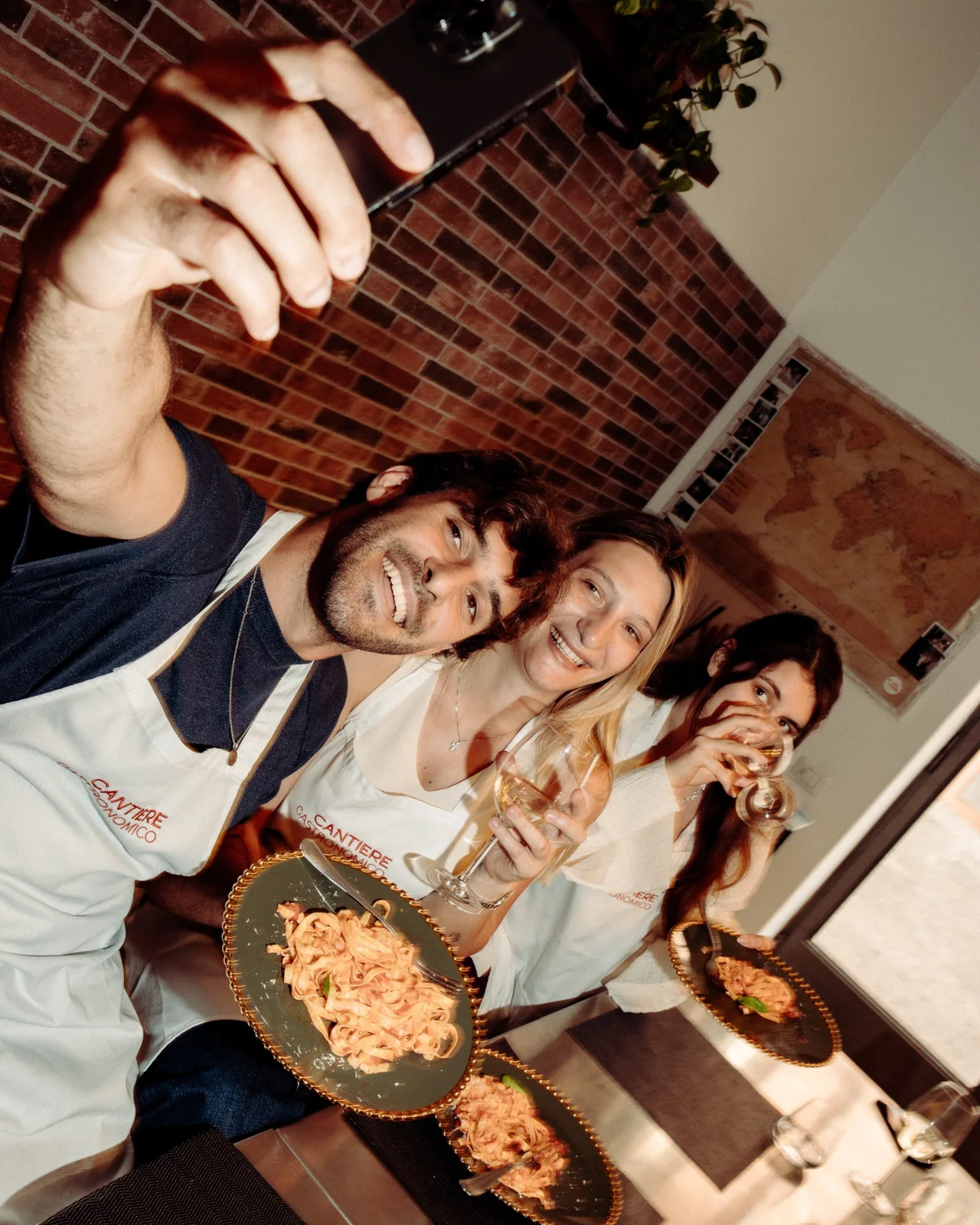 Guests with plates of pasta and wine in the studio